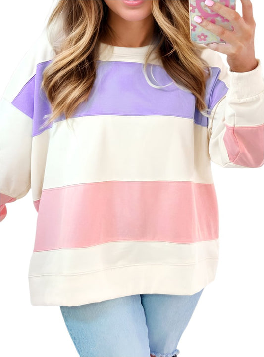 Woman wearing pastel color block oversized sweatshirt, styled with jeans.
