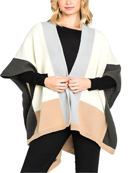 Woman wearing a color-blocked open-front poncho in neutral tones.
