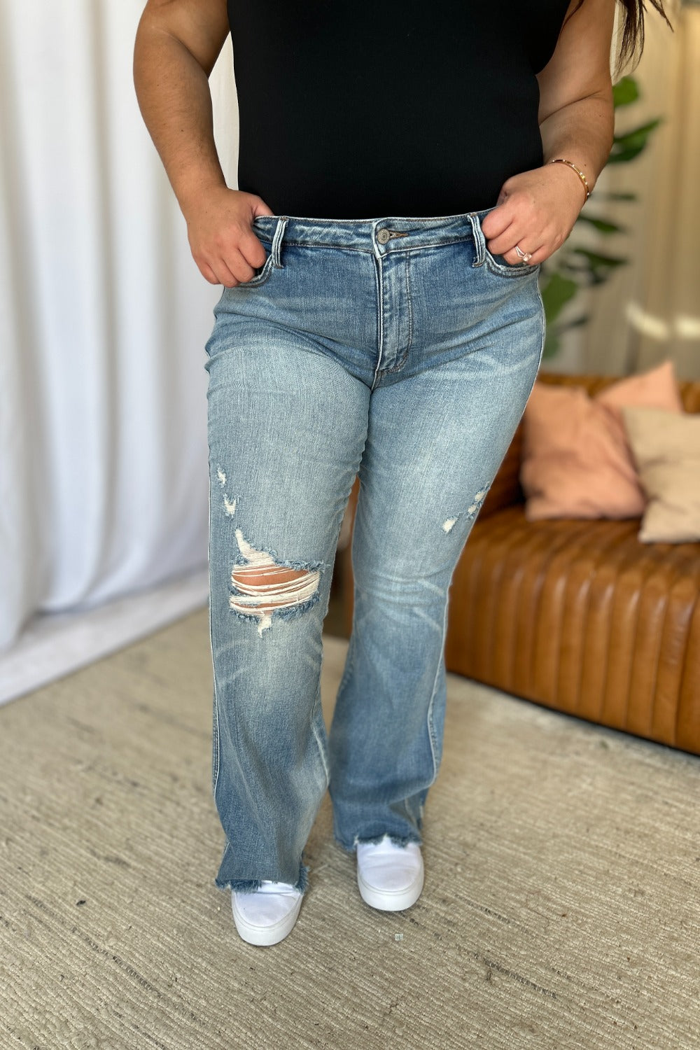 Close-up of raw hem and distressed accents on flare jeans.