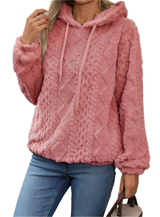 Woman wearing a plush coral hoodie with chevron texture.
