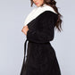 Side angle of a black sherpa-lined hooded robe, featuring a belted waist and side pockets.
