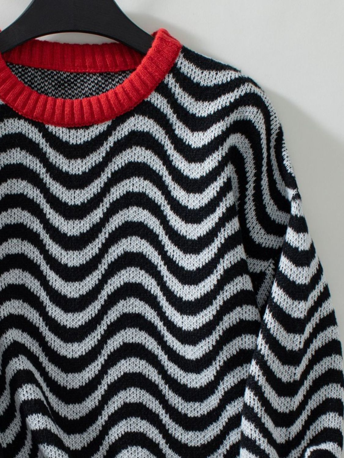 Close-up of the soft, cozy fabric on the black wavy stripe sweater, ideal for colder days.

