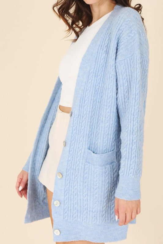 Cozy blue cable knit cardigan featuring a button-up front and V-neck.
