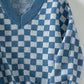 Soft blue and white checkerboard sweater for a chic, modern look.
