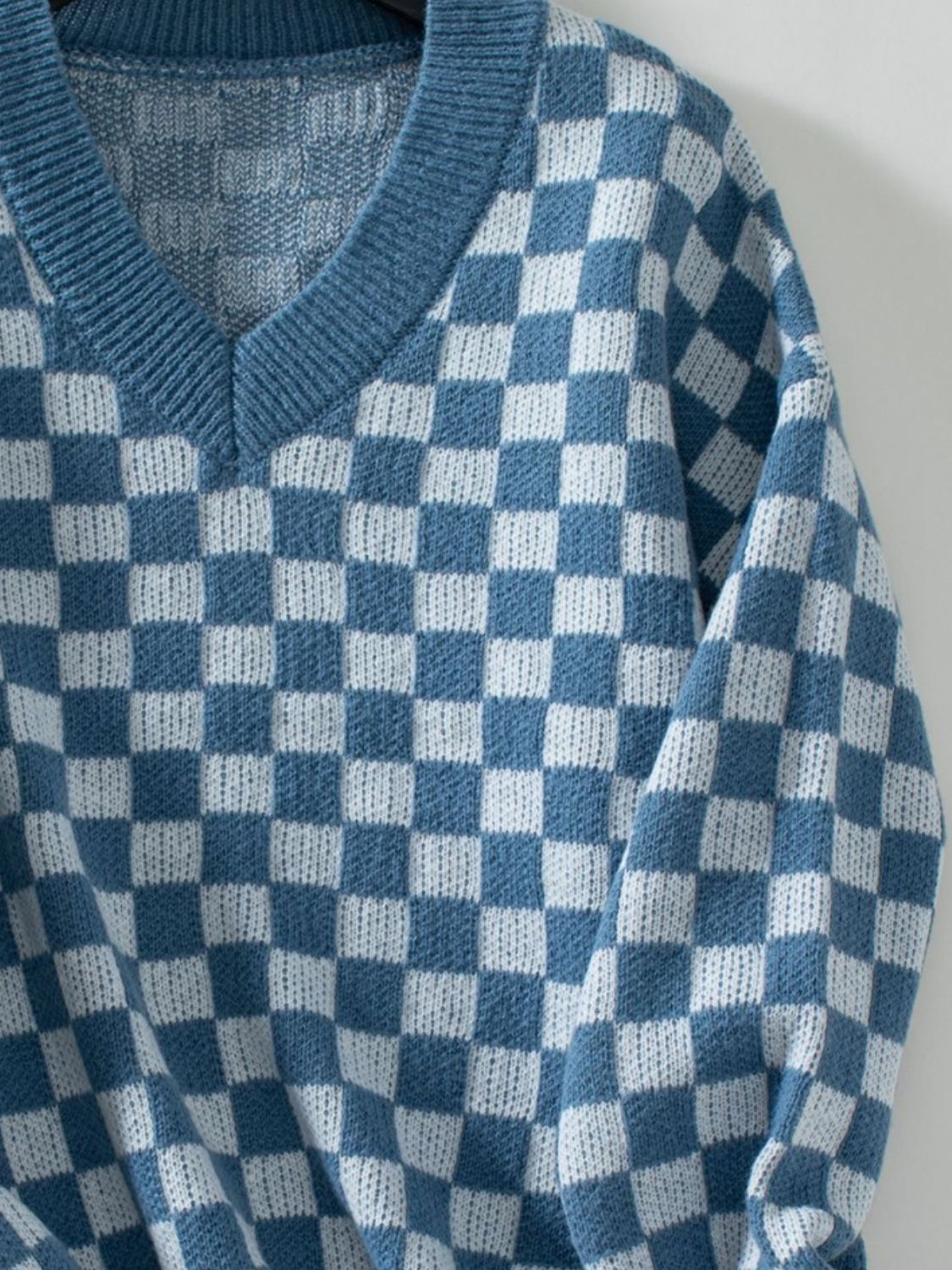 Soft blue and white checkerboard sweater for a chic, modern look.
