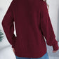 Chunky cable knit cardigan in burgundy perfect for layering over casual outfits.
