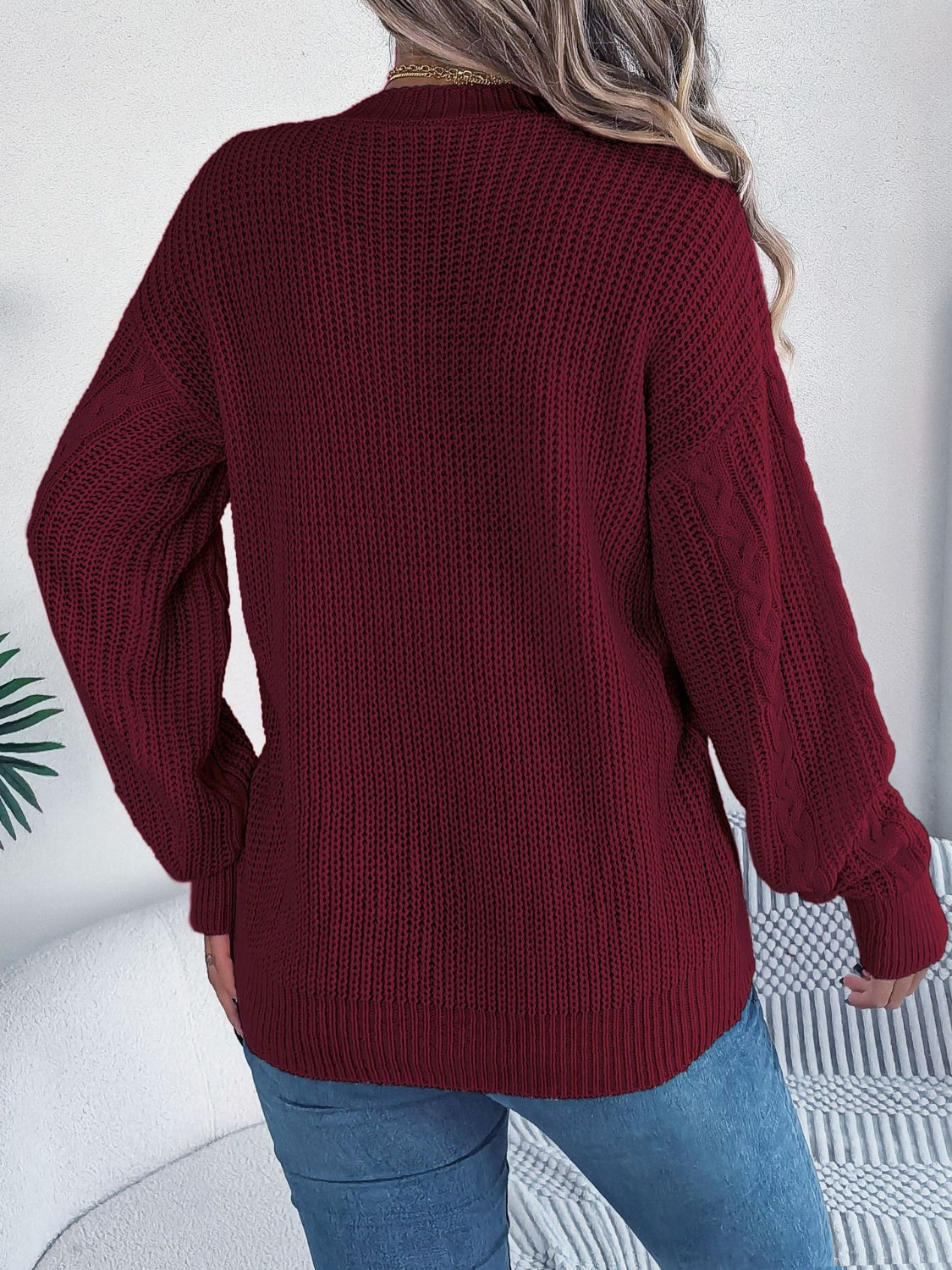 Chunky cable knit cardigan in burgundy perfect for layering over casual outfits.
