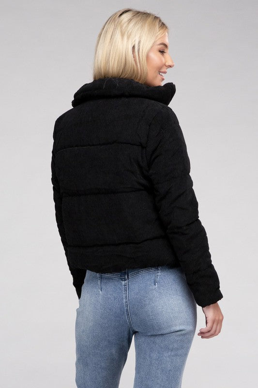 Black corduroy jacket for women with zip-up closure, styled casually with blue jeans.
