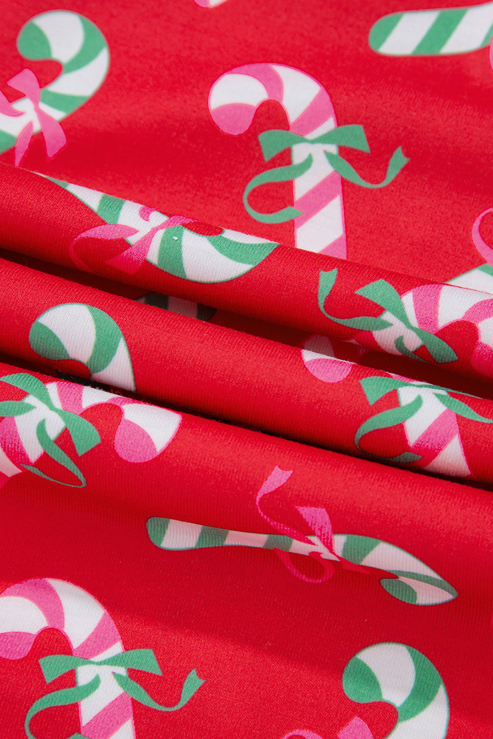 Close-up of the festive candy cane print and green contrast trim on a holiday pajama set.





