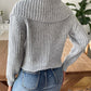 Woman wearing a soft gray wide-collar sweater, perfect for layering.
