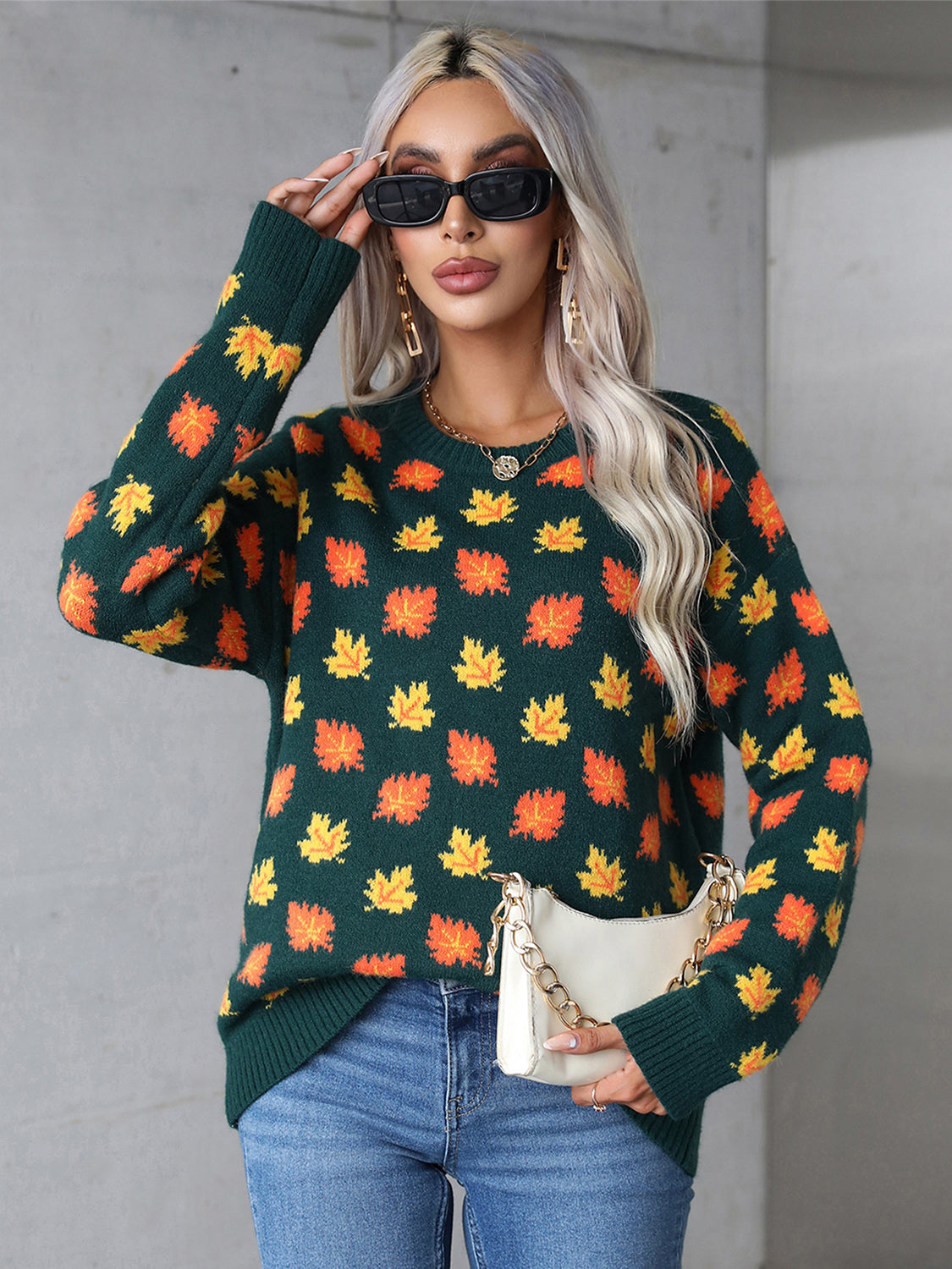 Cozy green sweater featuring vibrant orange leaves and a comfortable stretch for fall wear.

