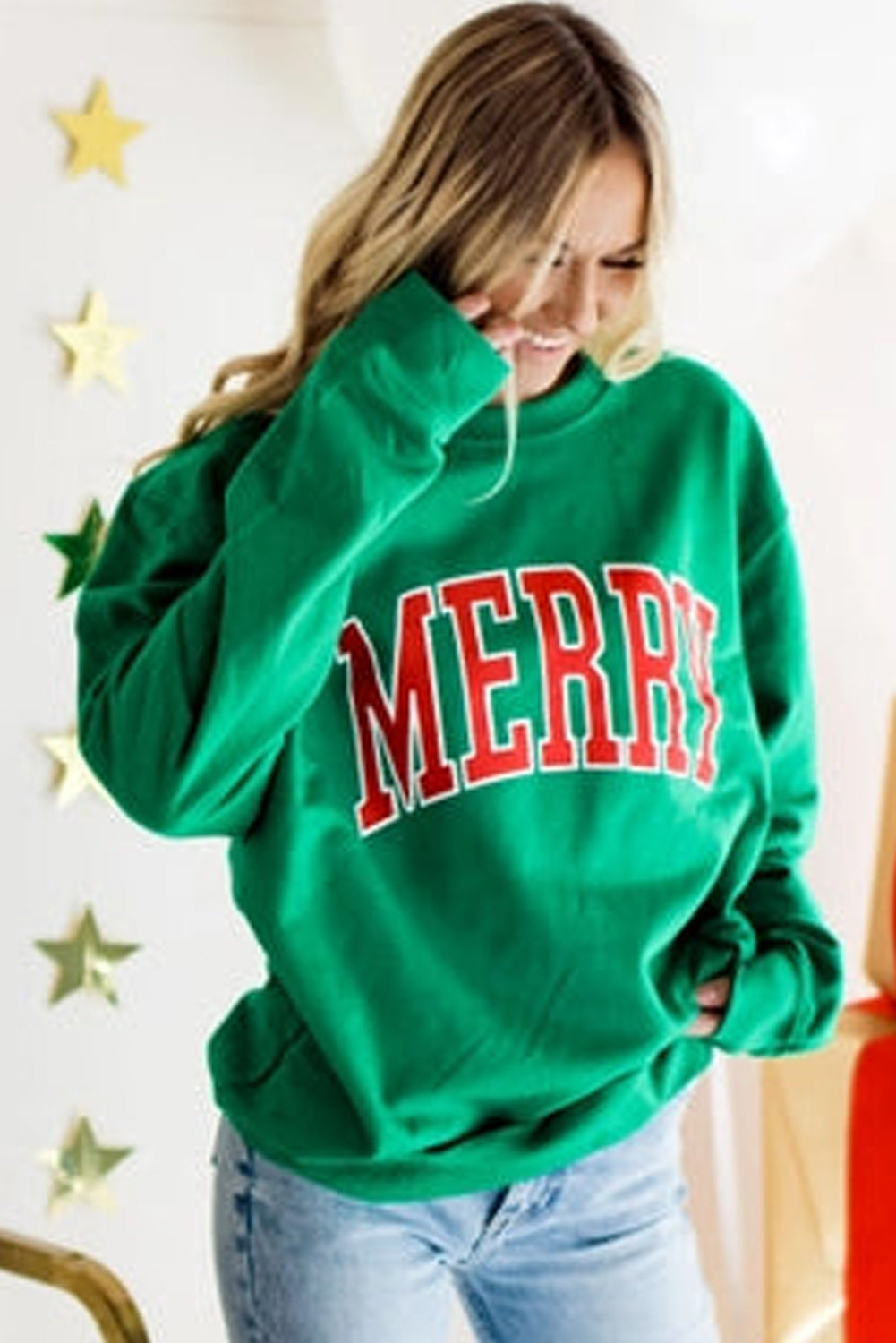 Cozy green holiday sweater with bold lettering and relaxed fit for women.
