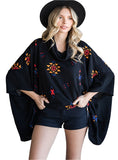 Model in a black Aztec print poncho with a relaxed, oversized fit.