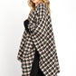 Cozy black plaid shawl draped over shoulders with casual outfit.
