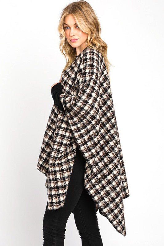 Cozy black plaid shawl draped over shoulders with casual outfit.
