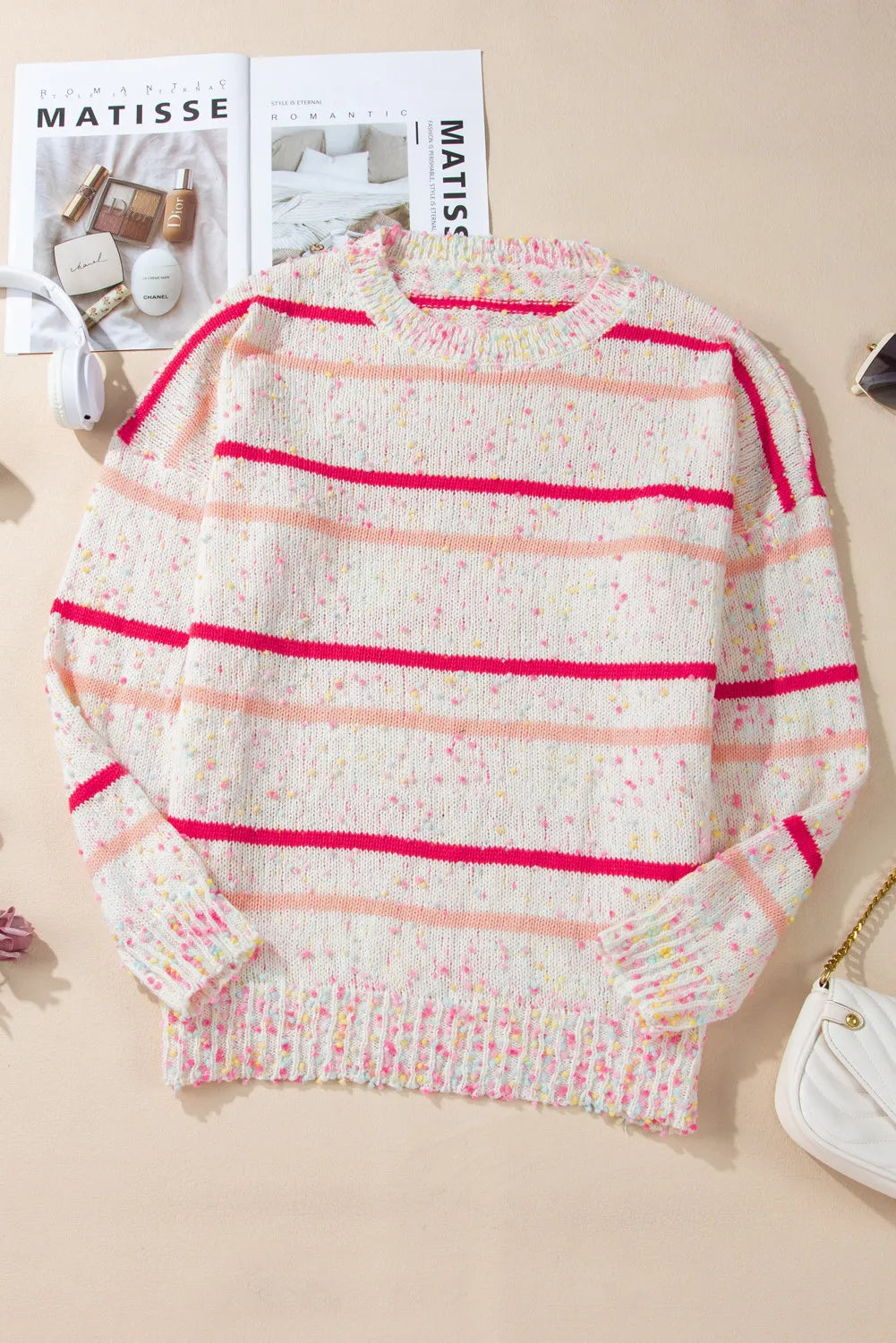 Plus-size cozy knit sweater featuring speckled texture and pink stripes.
