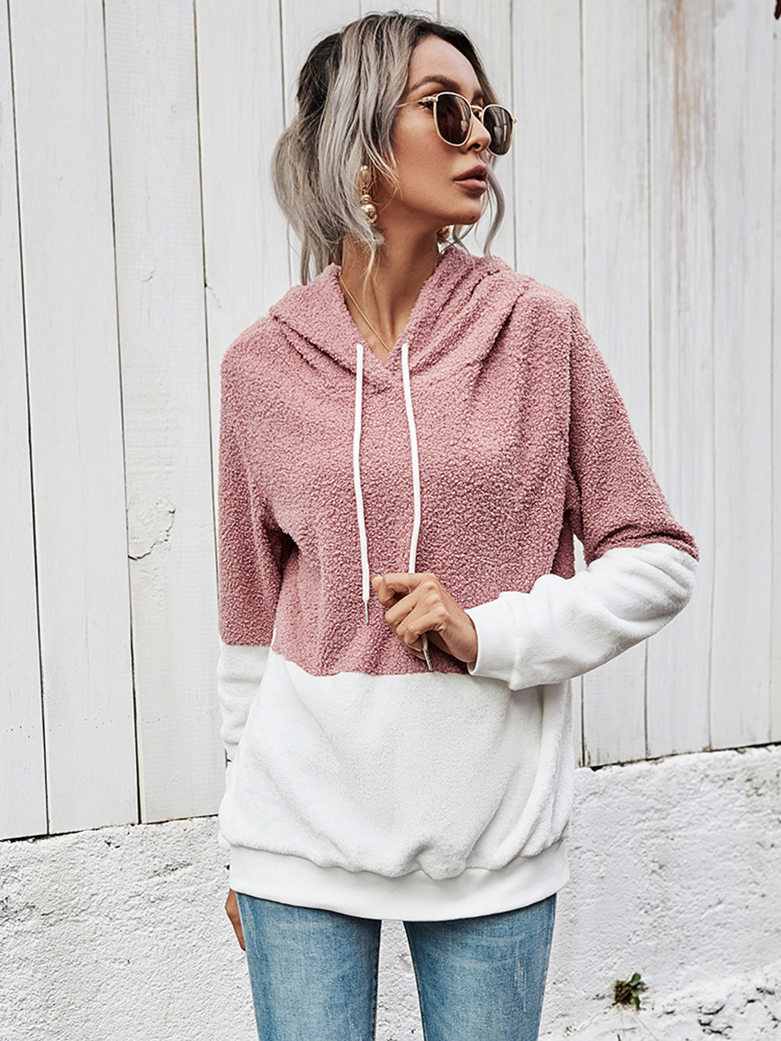 A relaxed-fit pullover hoodie in pink and white sherpa fabric.
