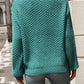 Back view of relaxed fit turquoise textured knit sweater on woman outdoors
