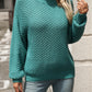 Woman wearing cozy textured knit mock neck sweater in turquoise with jeans
