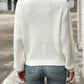 Back view of relaxed fit white textured knit sweater on woman outdoors
