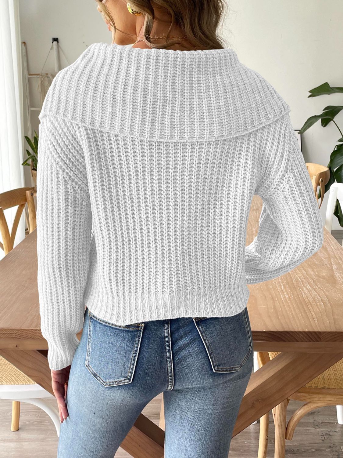 White cable-knit sweater with a modern wide collar design.
