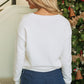 Back of the festive tinsel graphic on a white sweater with "Merry & Bright" lettering, ideal for Christmas parties.