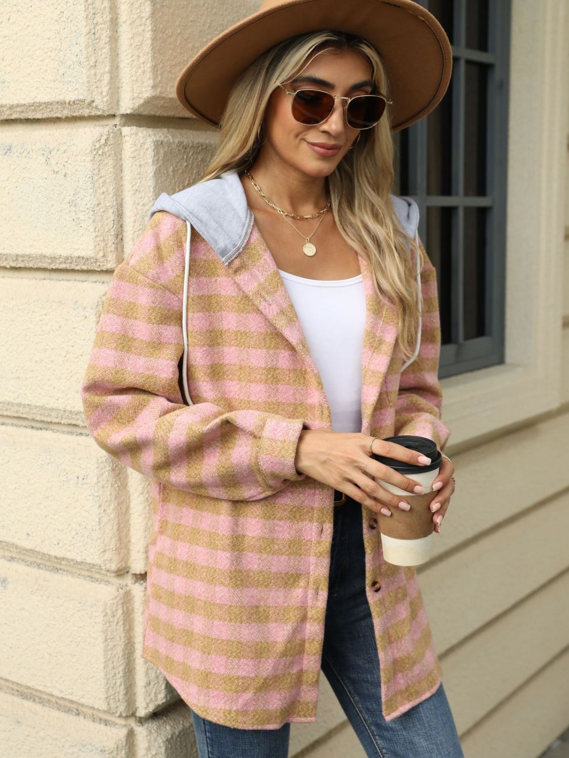 Peach plaid jacket with hood styled with jeans and a belt
