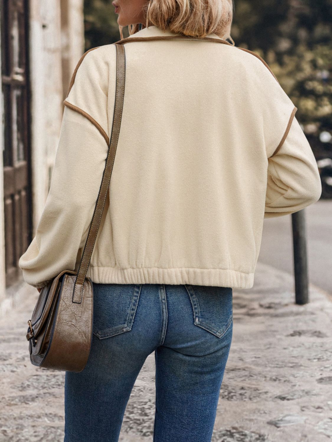 Back view of women’s cream buttoned zip-up jacket
