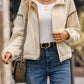 Cream zip-up jacket layered over casual outfit
