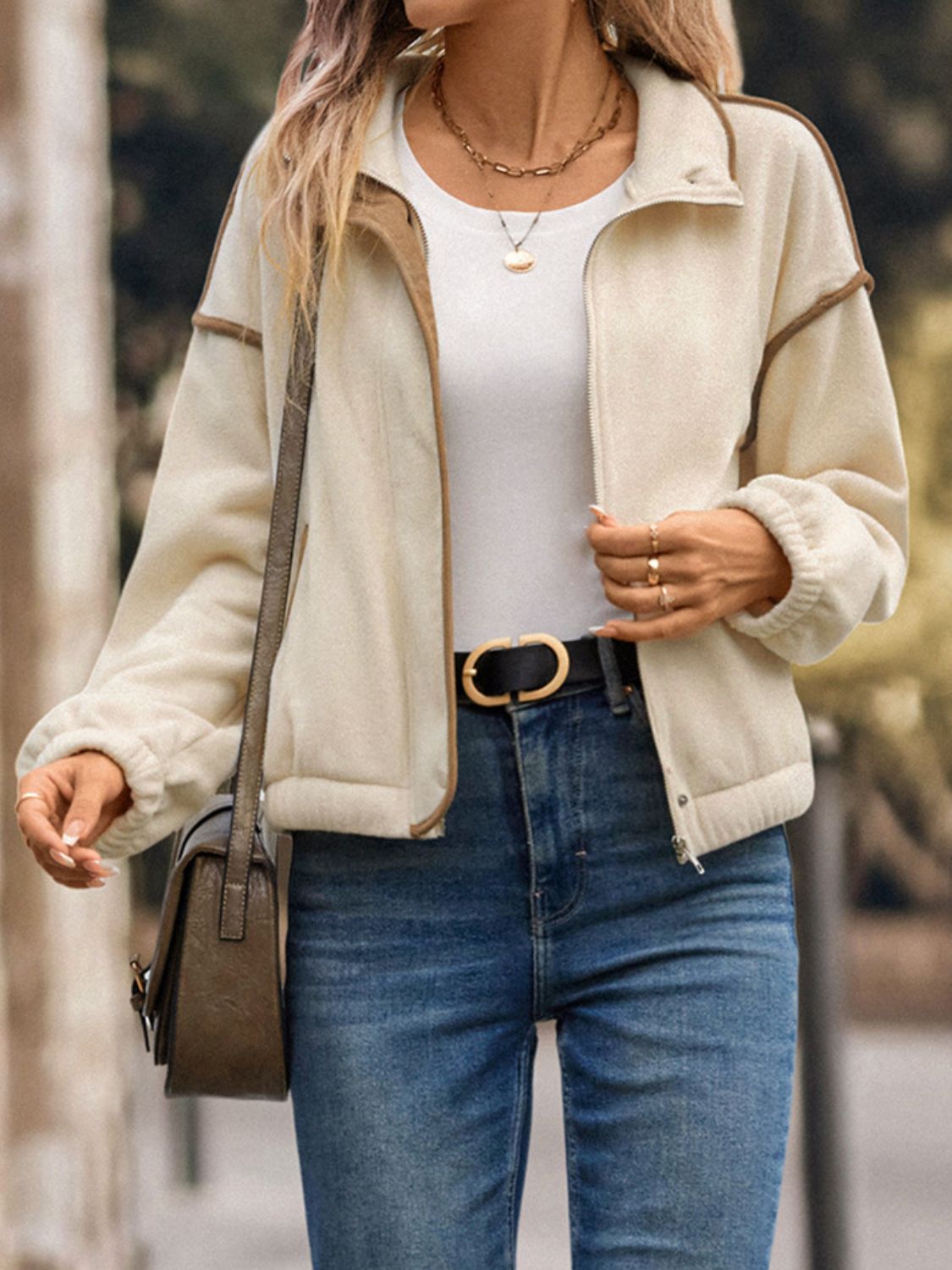 Cream zip-up jacket layered over casual outfit
