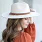 Cream wide brim Panama hat with a tassel belt shown from the side profile.
