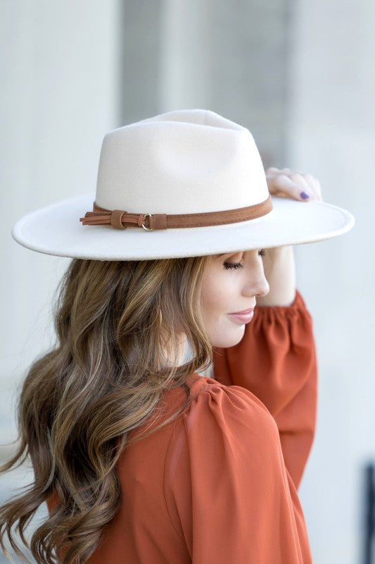 Cream wide brim Panama hat with a tassel belt shown from the side profile.
