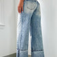 Back view of cuffed light wash wide leg jeans featuring a structured design.
