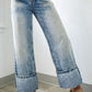 Functional pocket detail on cuffed light wash wide leg jeans for practicality.
