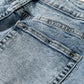 Texture closeup of cuffed light wash wide leg jeans highlighting fabric quality and finish.
