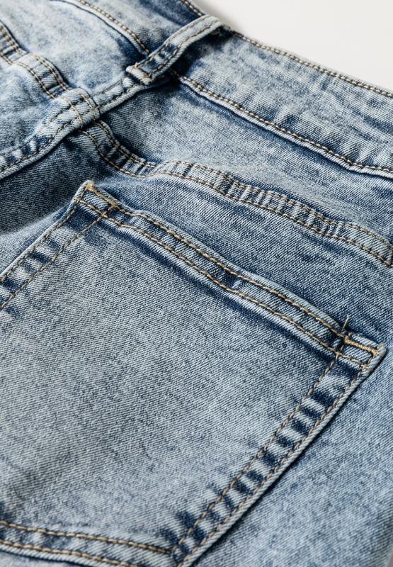 Texture closeup of cuffed light wash wide leg jeans highlighting fabric quality and finish.
