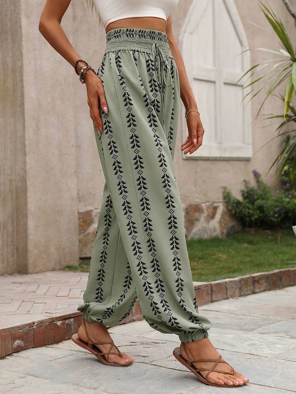 Green drawstring pants featuring a stylish bohemian print