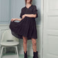 Black boho dress with a tiered silhouette and feminine ruffled sleeves.