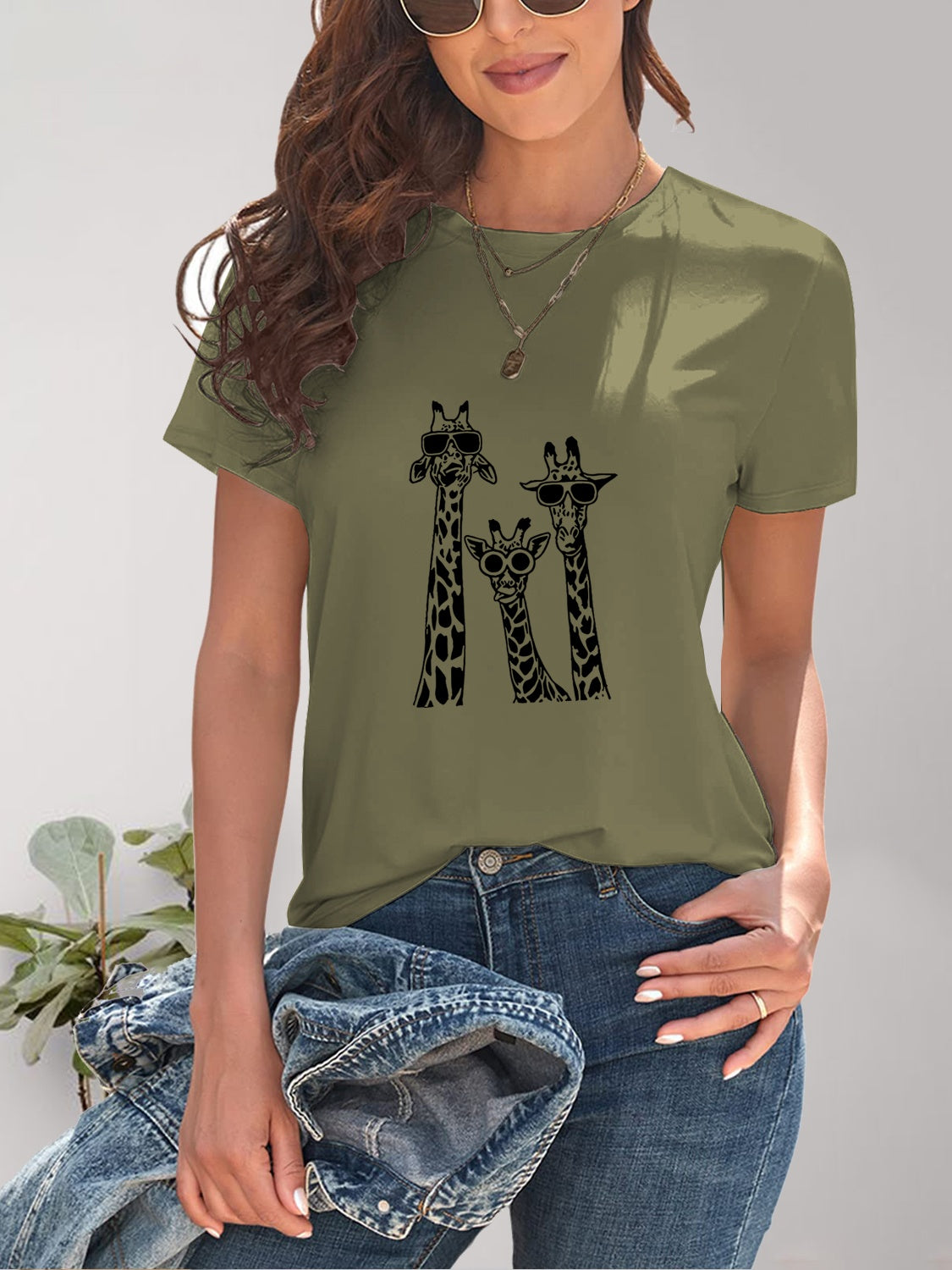 Green tee with three giraffes wearing sunglasses graphic