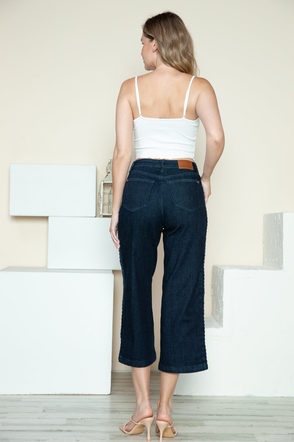 Wide-leg Judy Blue jeans styled with neutral heels for a chic look.
