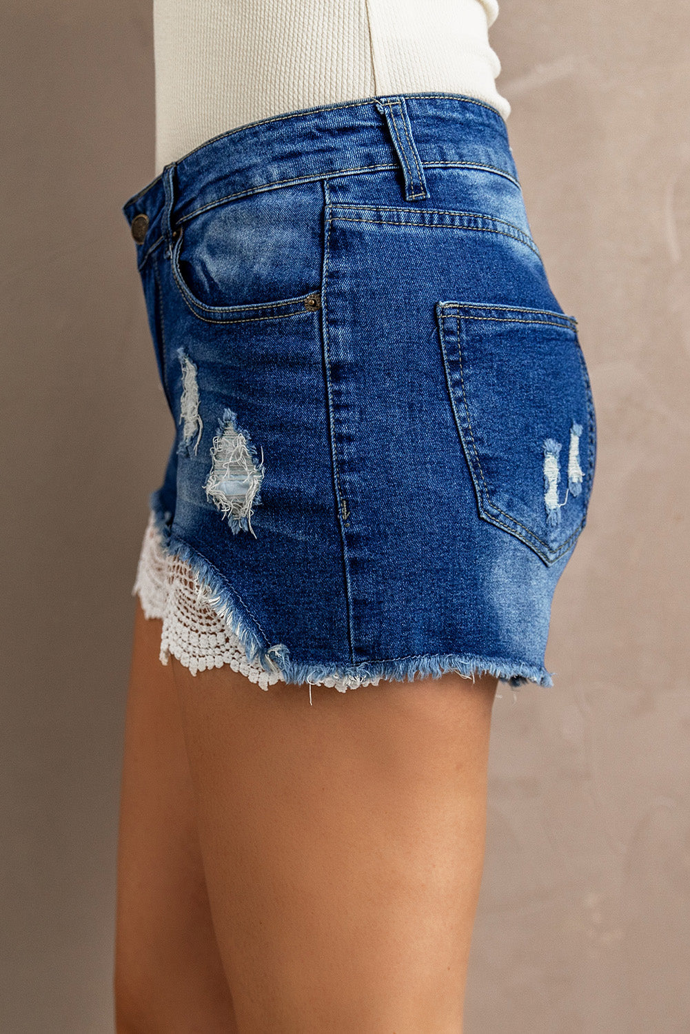Discover the perfect blend of rugged charm and delicate femininity with our Spliced Lace Distressed Denim Shorts. Elevate your summer style!