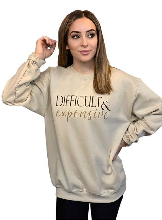 Woman wearing a beige "Difficult & Expensive" graphic sweatshirt
