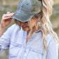 Olive distressed messy bun hat cap with ponytail opening
