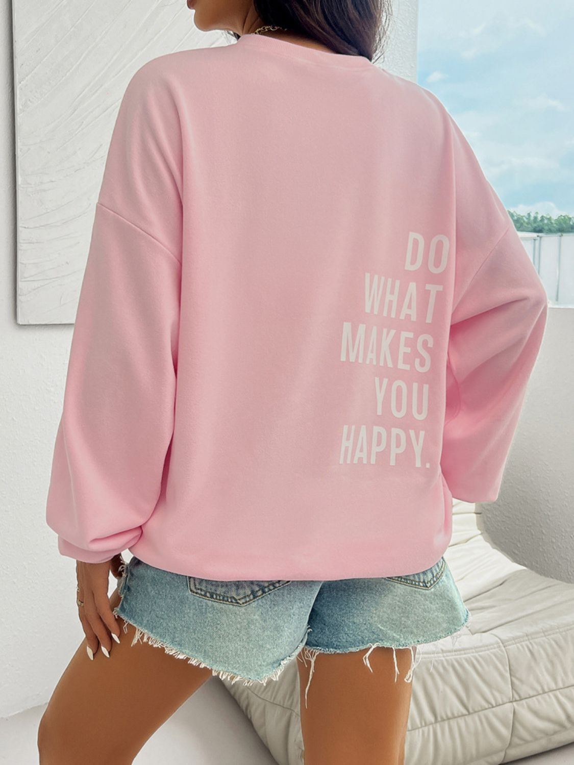 Back view of motivational graphic on pink oversized sweatshirt.
