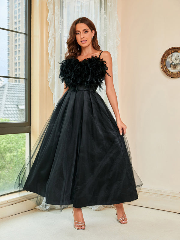 High-waisted black dress with mesh overlay and feather details for a bold look.
