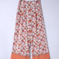 White and orange floral palazzo pants featuring intricate hem designs