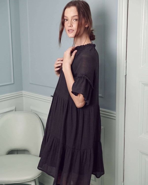 Black boho dress with a tiered silhouette and feminine ruffled sleeves.