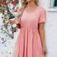 Coral V-neck dress with puff sleeves and a flared skirt.