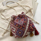Wine-colored pouch bag with vibrant geometric designs and tassel accents.