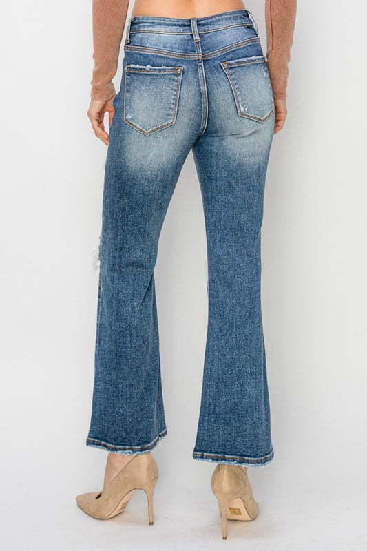 Edgy high-rise ankle flare jeans with ripped patches and vintage-inspired cut
